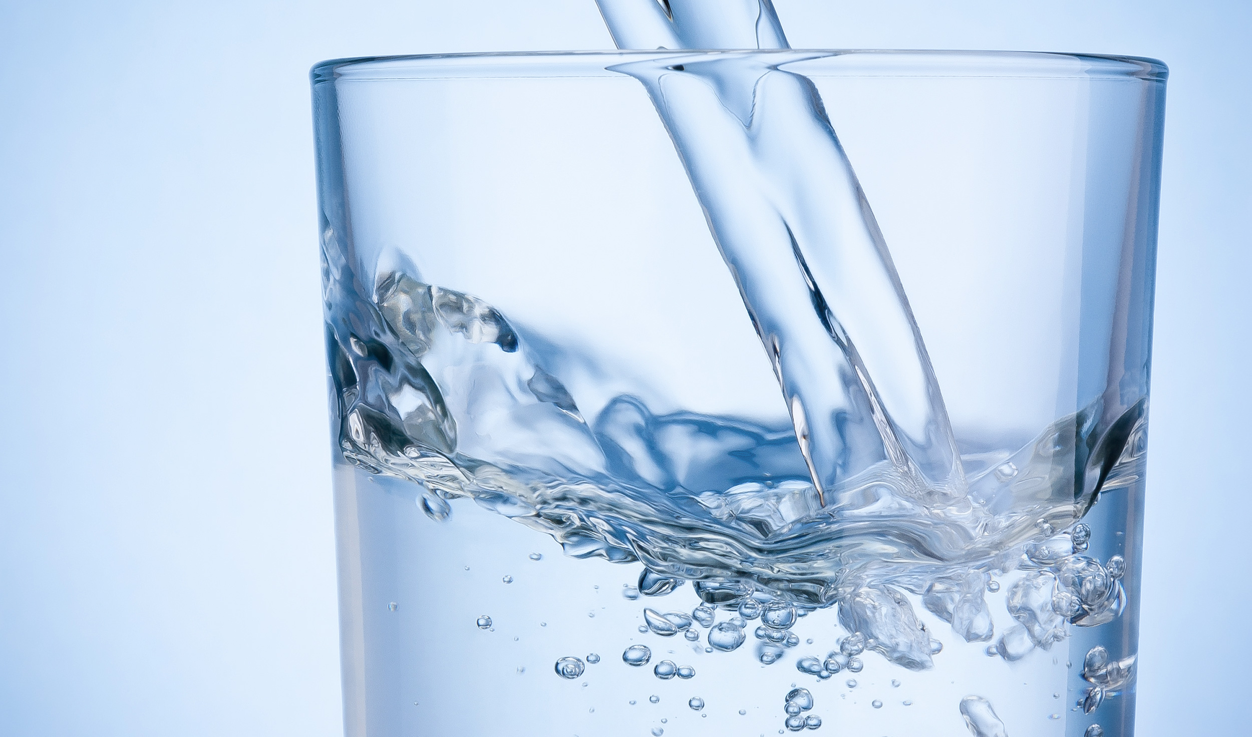 Trinkwasser in Wasserglas einschenken
